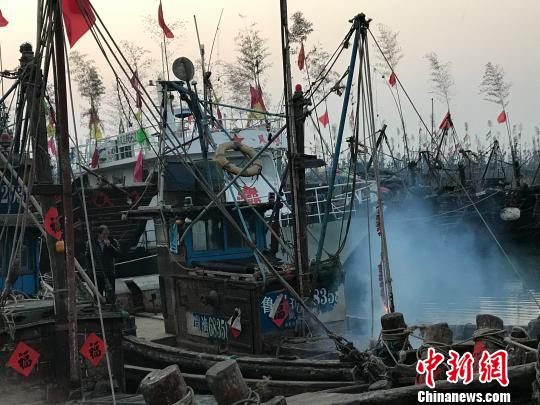 “財神日”當天,漁民在船上祭拜“龍王”放鞭炮。 郭亞楠 攝